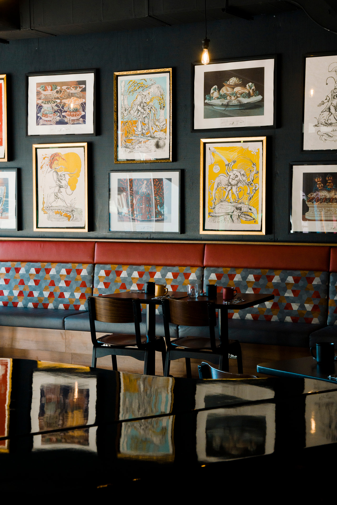 Café banquette beneath a wall of framed prints