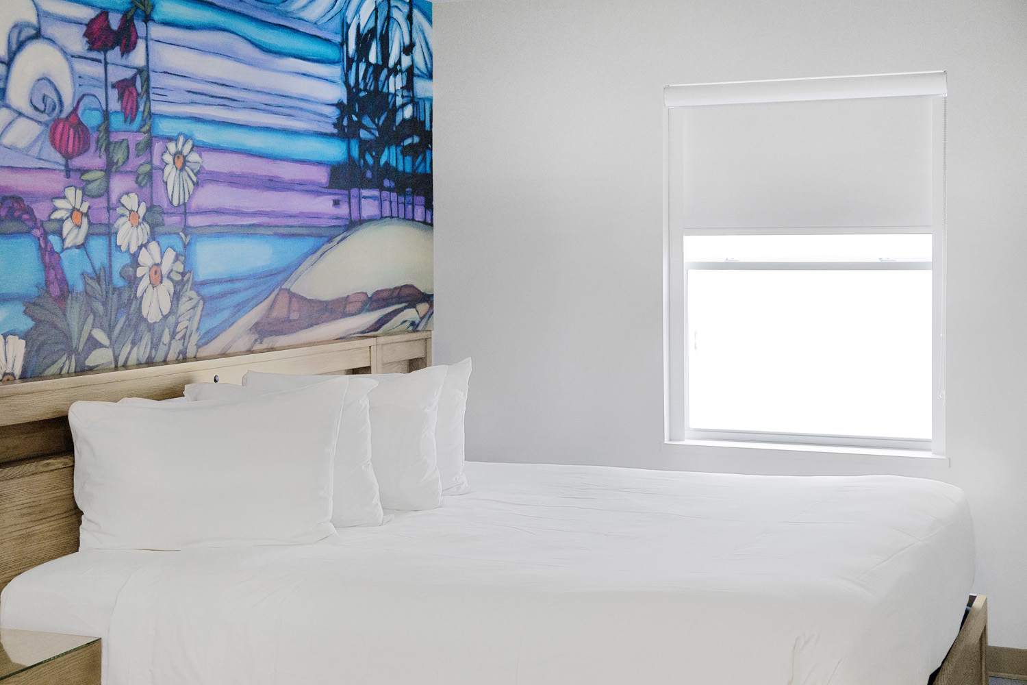 Bed against a blue and violet mural