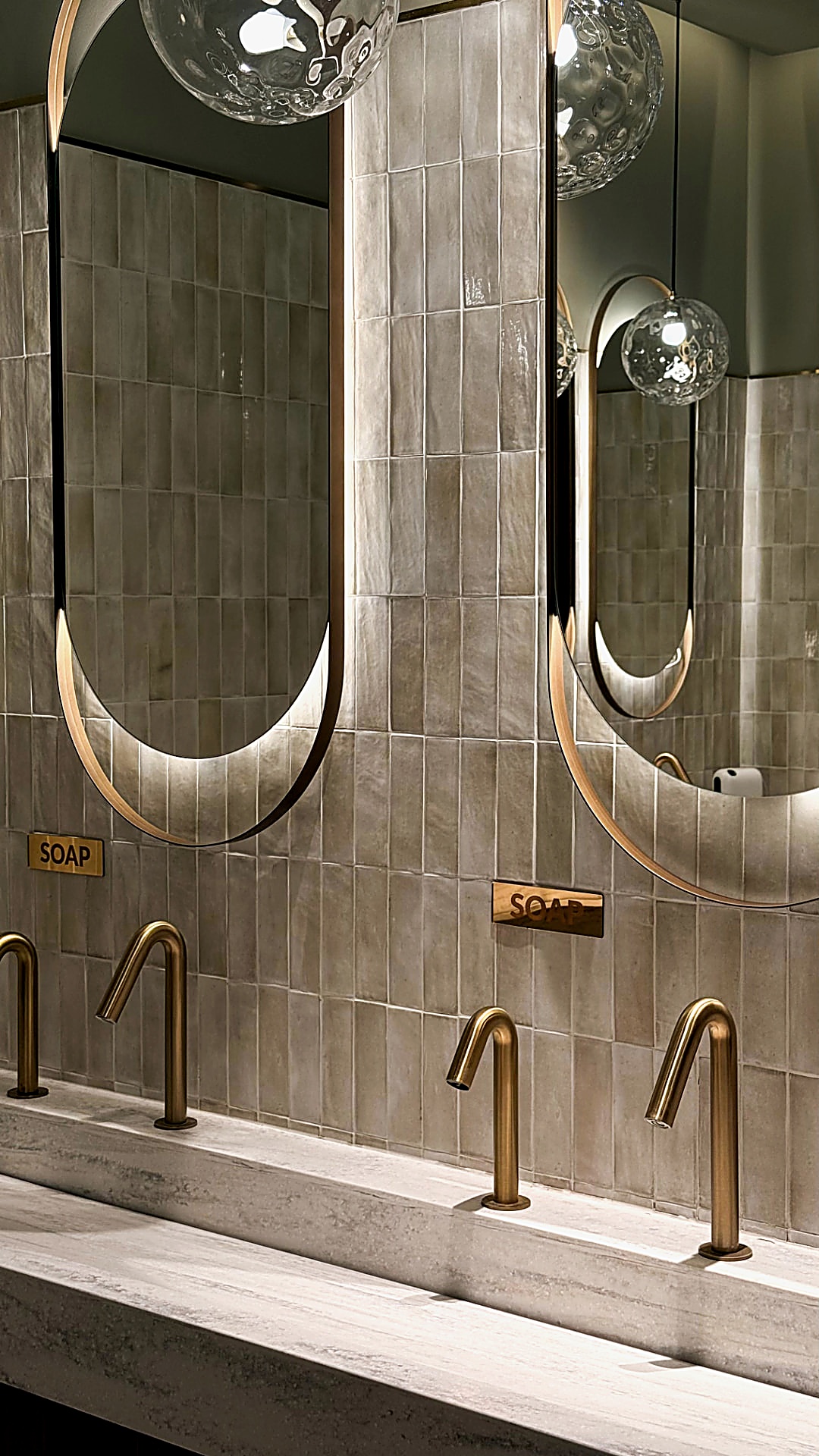 Brass taps, handmade tiles and layered reflections